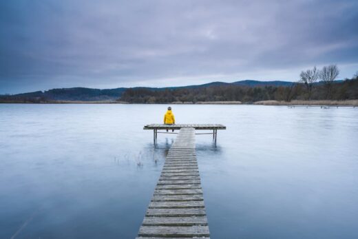 Dziecięca żałoba. Samotne dziecko siedzące na pomoście.