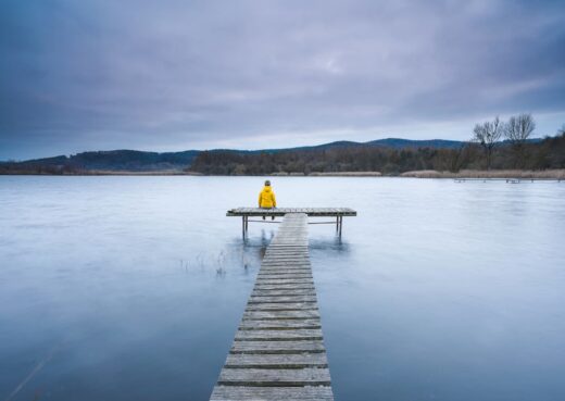 Dziecięca żałoba. Samotne dziecko siedzące na pomoście.